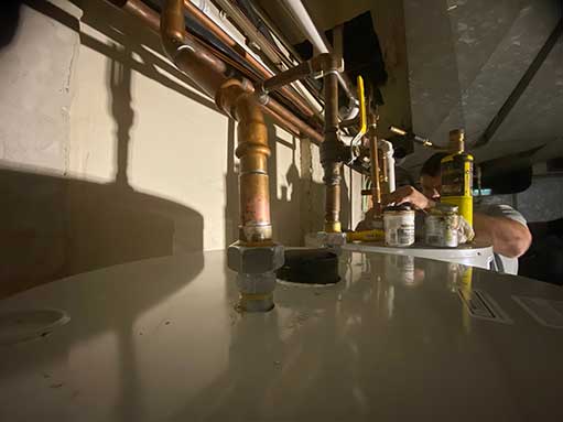 a plumber performing a water heater repair in woodridge.