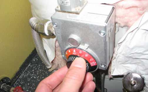 a person changing their water heater temperature settings