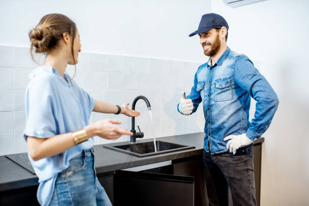 a woman asking her plumber questions before he starts any work